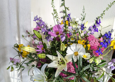 A vase of colorful flowers sitting on a floor.