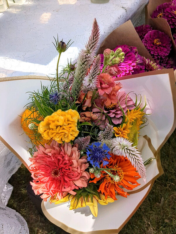 Boldly colored flower arrangements wrapped in white paper.