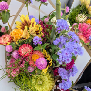 Colorful flower bouquet wrapped in white paper.